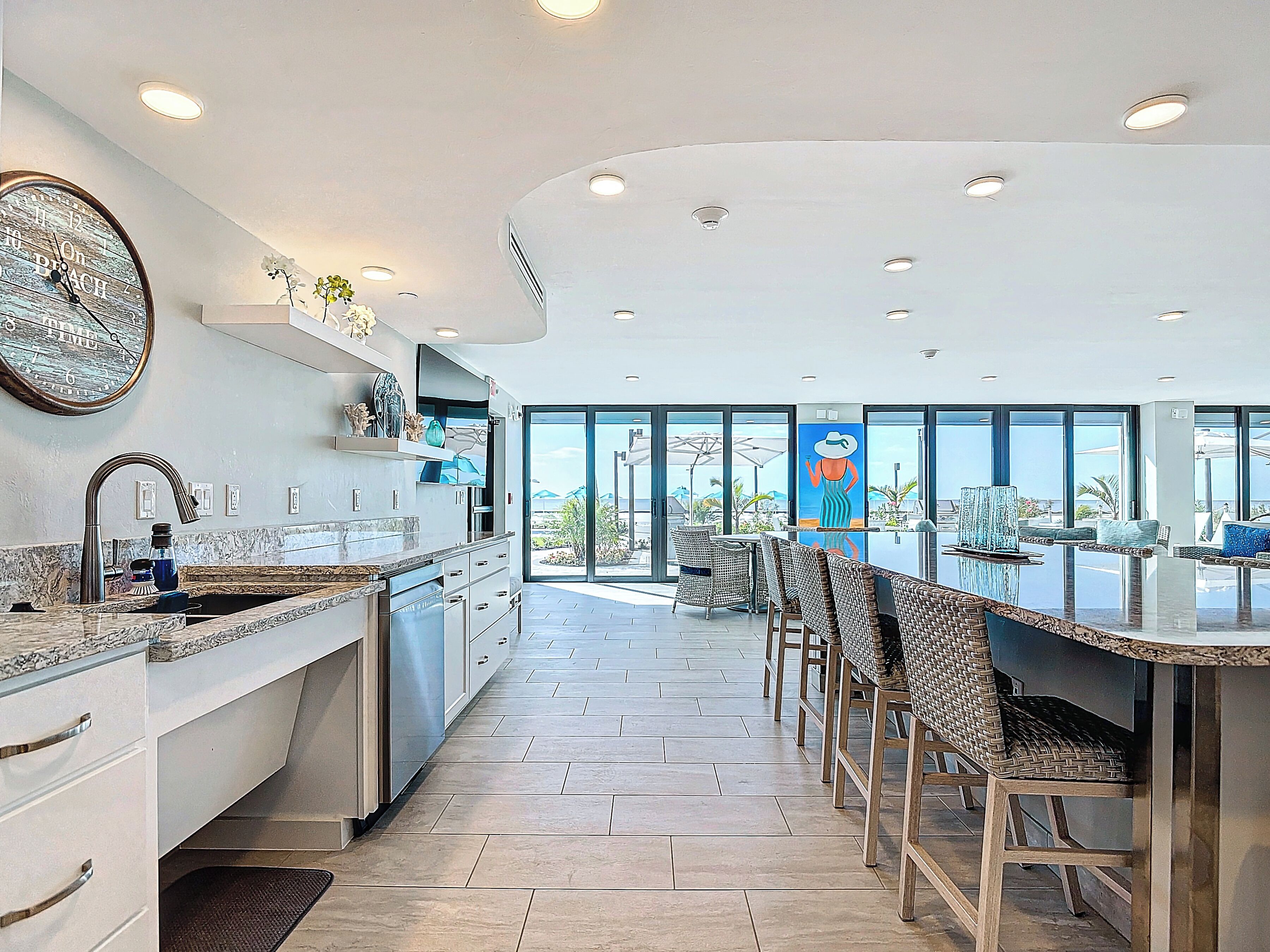 Una cocina moderna con una isla grande, electrodomésticos integrados y vistas al exterior.