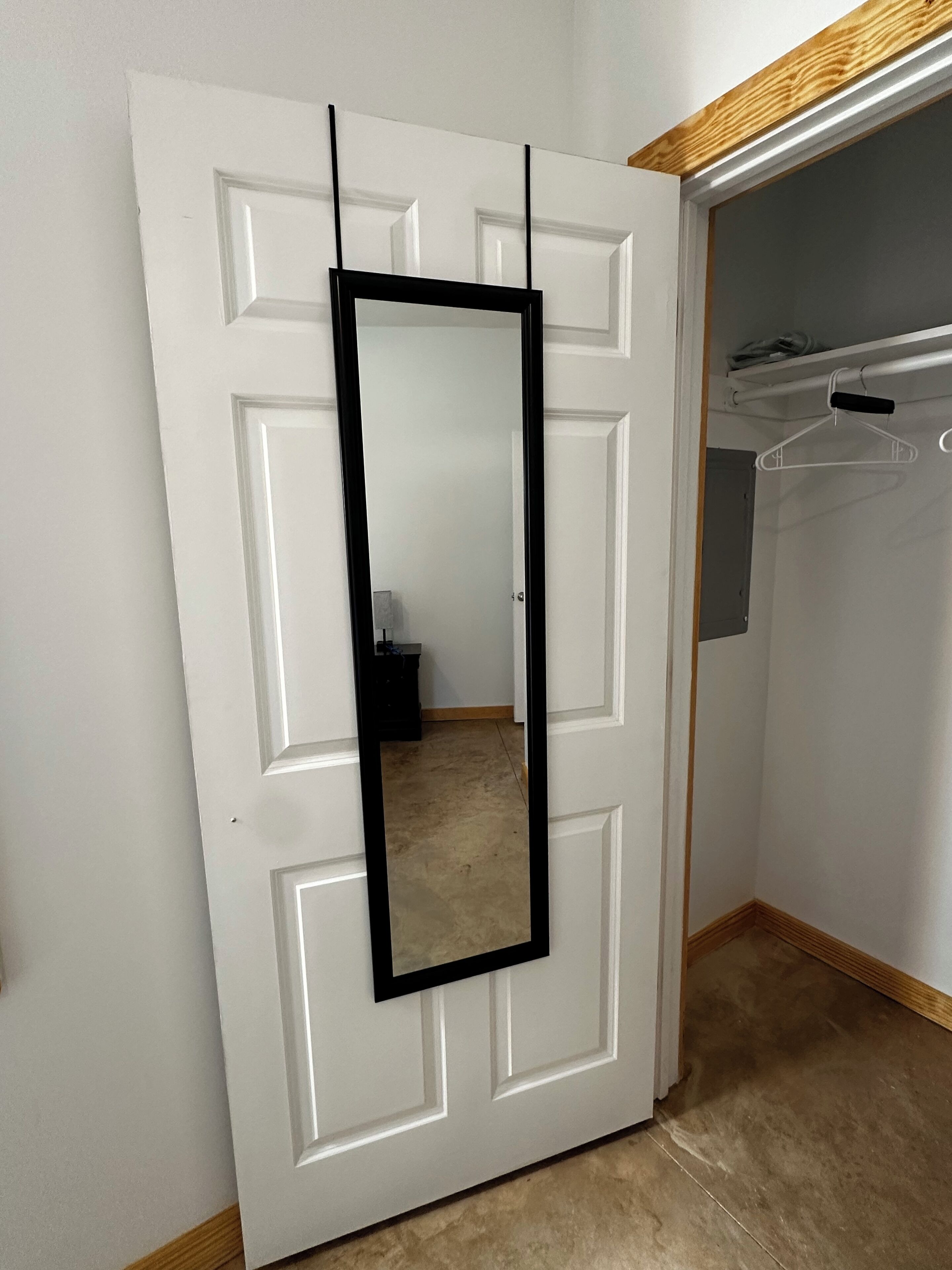 Une porte blanche avec un cadre de miroir noir.