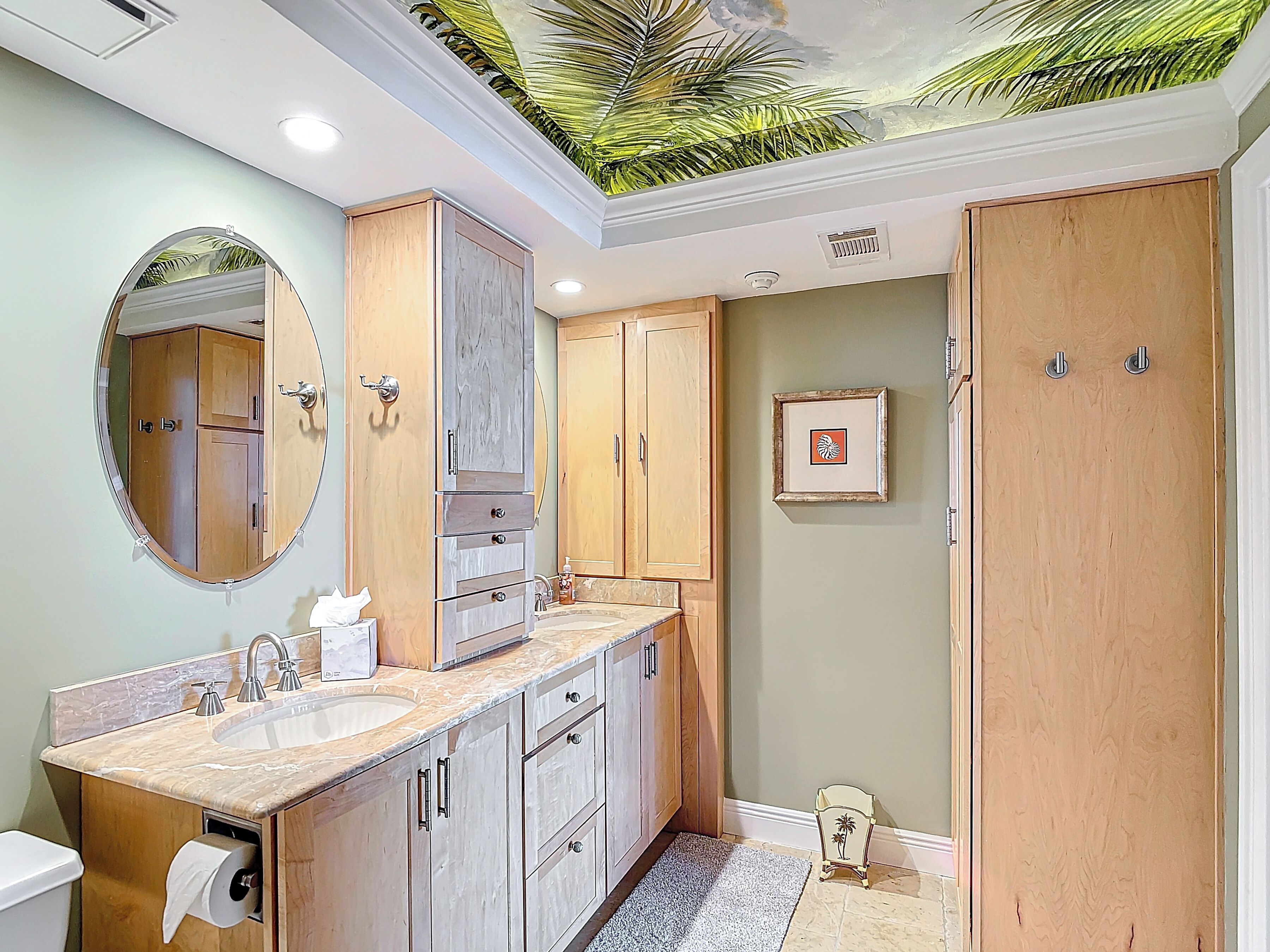 Une salle de bain avec un lavabo en marbre, des meubles en bois, un miroir et une fresque au plafond.
