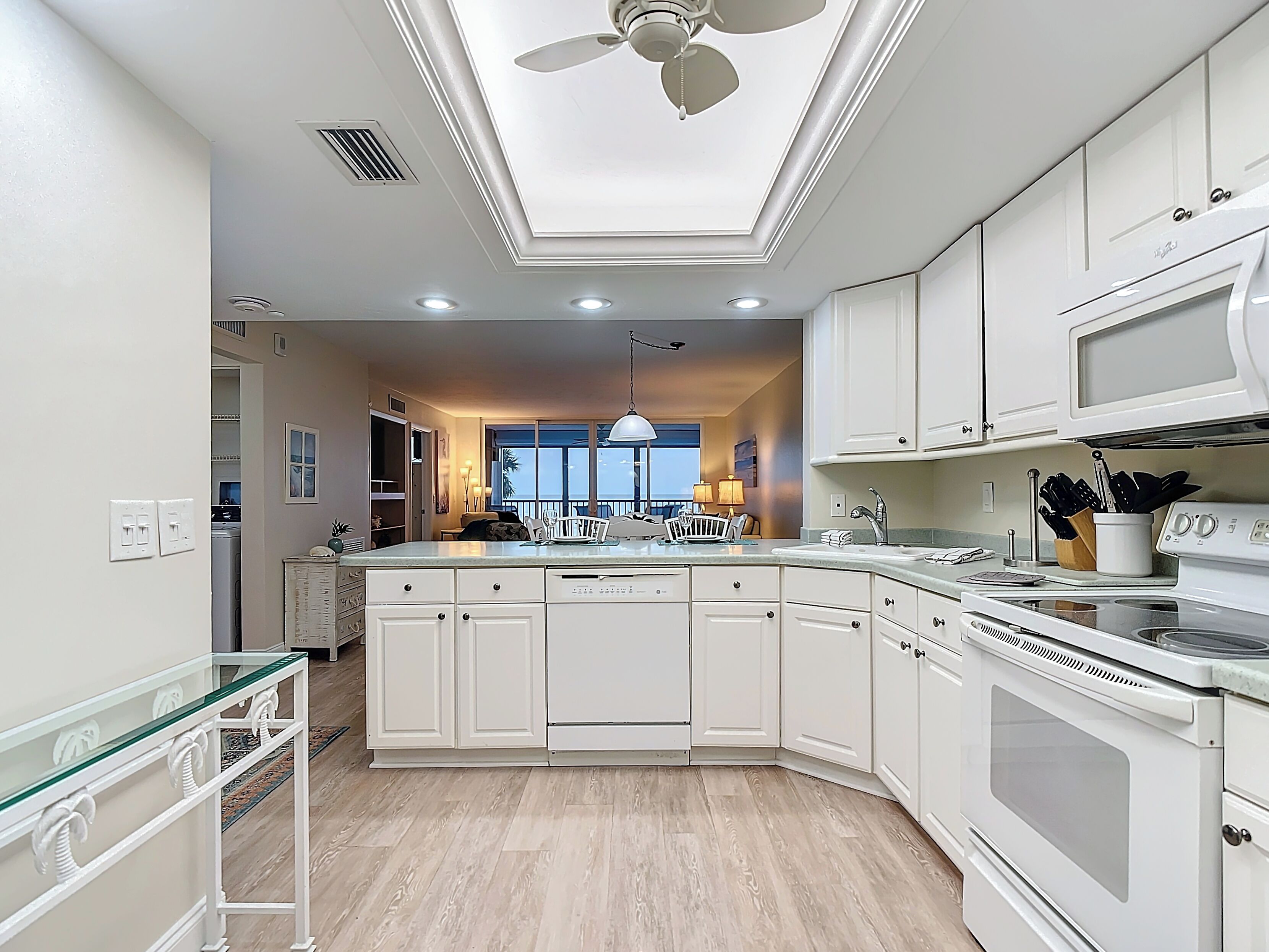 A modern kitchen with white cabinetry, a central island, and a built-in oven.