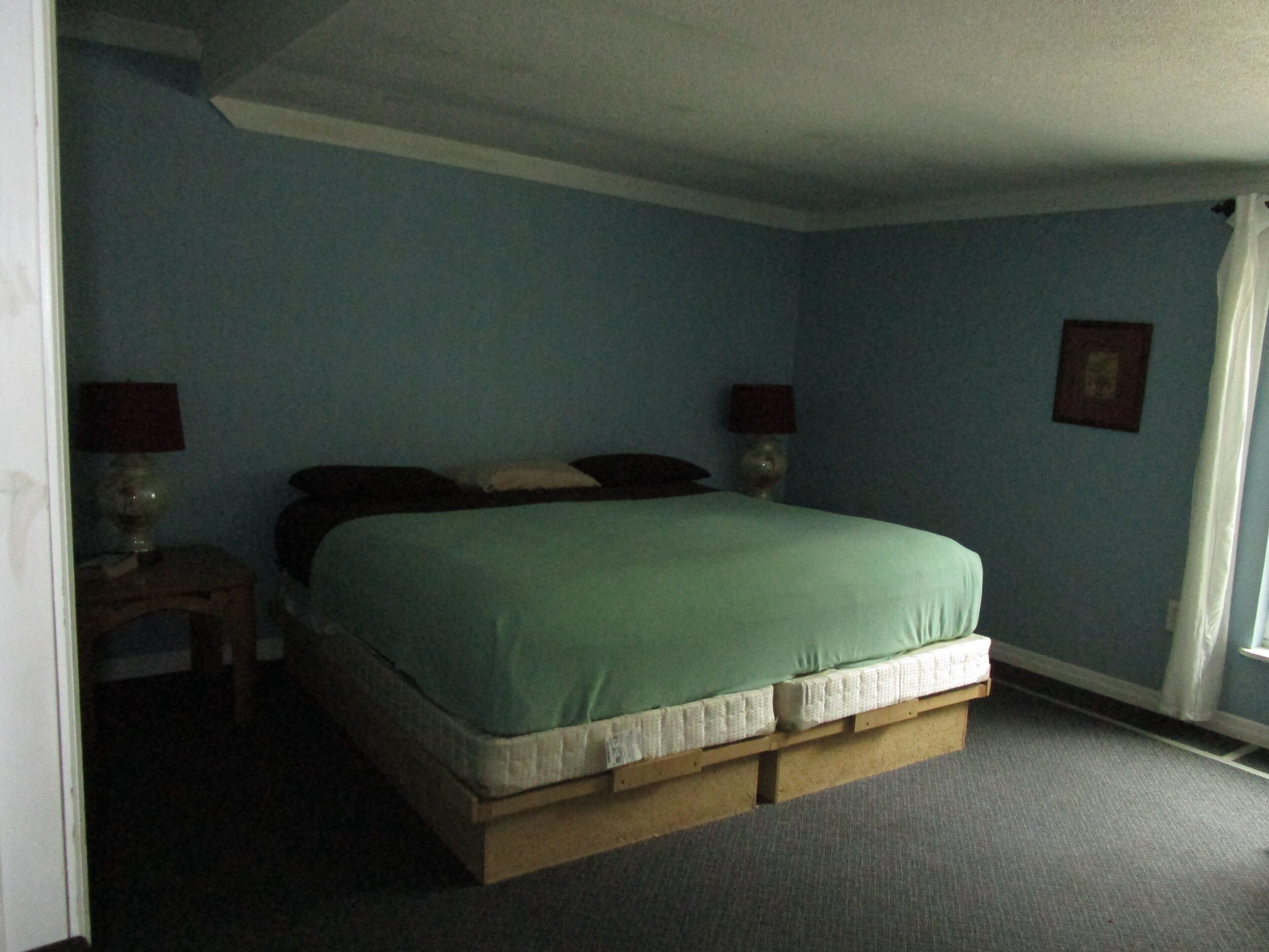A bedroom with a bed, two bedside tables, and a nightstand.
