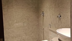 Et badeværelse med toilet, vask og brusebad.