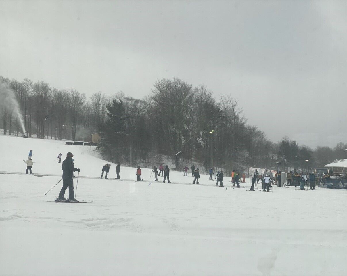 Une piste de ski avec des skieurs et des snowboardeurs.
