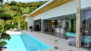 A modern house with a swimming pool, a patio, and a kitchen area visible through glass doors. - New single storey villa with sea view, all comforts, close to research area. (Bophut)