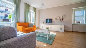 Un salon moderne avec un canapé, une table basse et un téléviseur posé sur un meuble.
