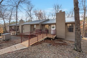 A row of cabins with a wooden deck and metal railing.