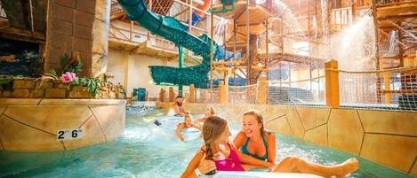 Parque acuático interior con toboganes y piscinas múltiples.