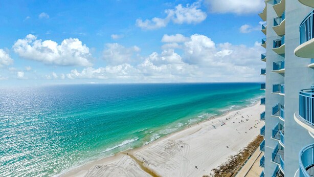 A beachfront hotel with a view of the ocean and beach.