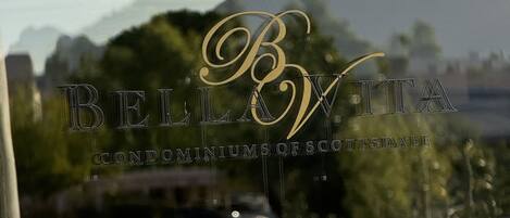A view through a window with the text "BELLVITA" and "CONDOMINIUMS OF SCOTTSDALE" visible.