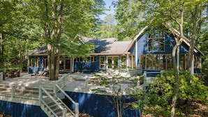 Een blauw huis met een overdekte veranda en een omheind terras.