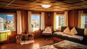A cozy room with wooden walls, a wooden ceiling, a bed, a chair, and a table. - Quaint vacation home in the mountains - pure relaxation and nature! (Lingenau)