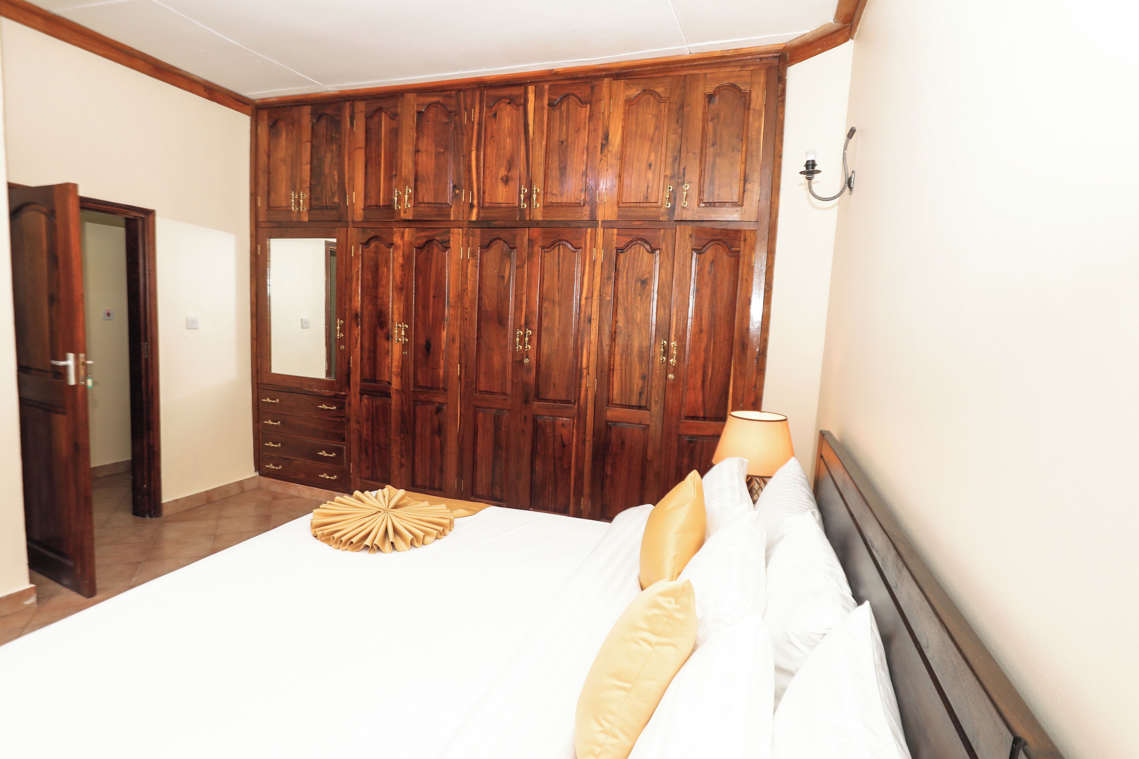 Une chambre à coucher avec un grand lit, une armoire en bois et une table de chevet.