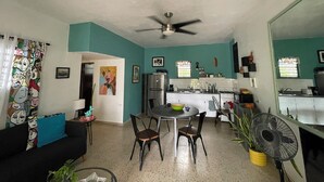 A compact living space with a dining area, kitchenette, and a ceiling fan.