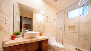A modern bathroom with a large mirror, a sink, and a toilet. - 2 Br Condo Near to the Beach - CDM 113 (Playa del Carmen)