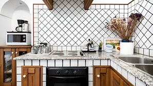 Una cocina equipada con microondas, estufa y lavabo.