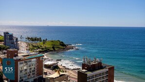 Un hôtel situé sur la côte, composé de plusieurs bâtiments, avec une plage et une vue dégagée sur l’océan.