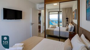 Une chambre d’hôtel équipée d’un lit, d’une télévision, d’un balcon avec vue et de la climatisation.
