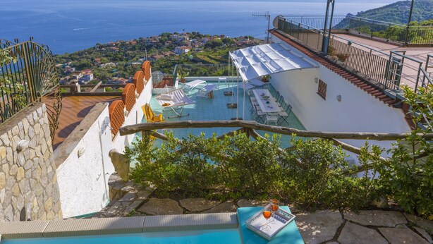 A rooftop pool with a view of the sea and a town in the background. - Villa Mapi in Massa Lubrense (Massa Lubrense)