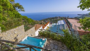 A pool area with a view of the sea, surrounded by stone walls and greenery. - Villa Mapi in Massa Lubrense (Massa Lubrense)