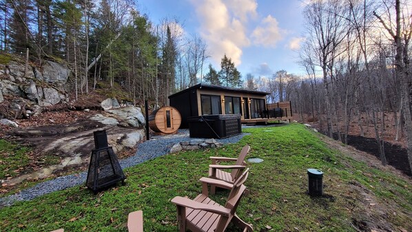 Une cabane dotée d’un bain à remous, d’un espace extérieur aménagé et d’un sentier en pierre.