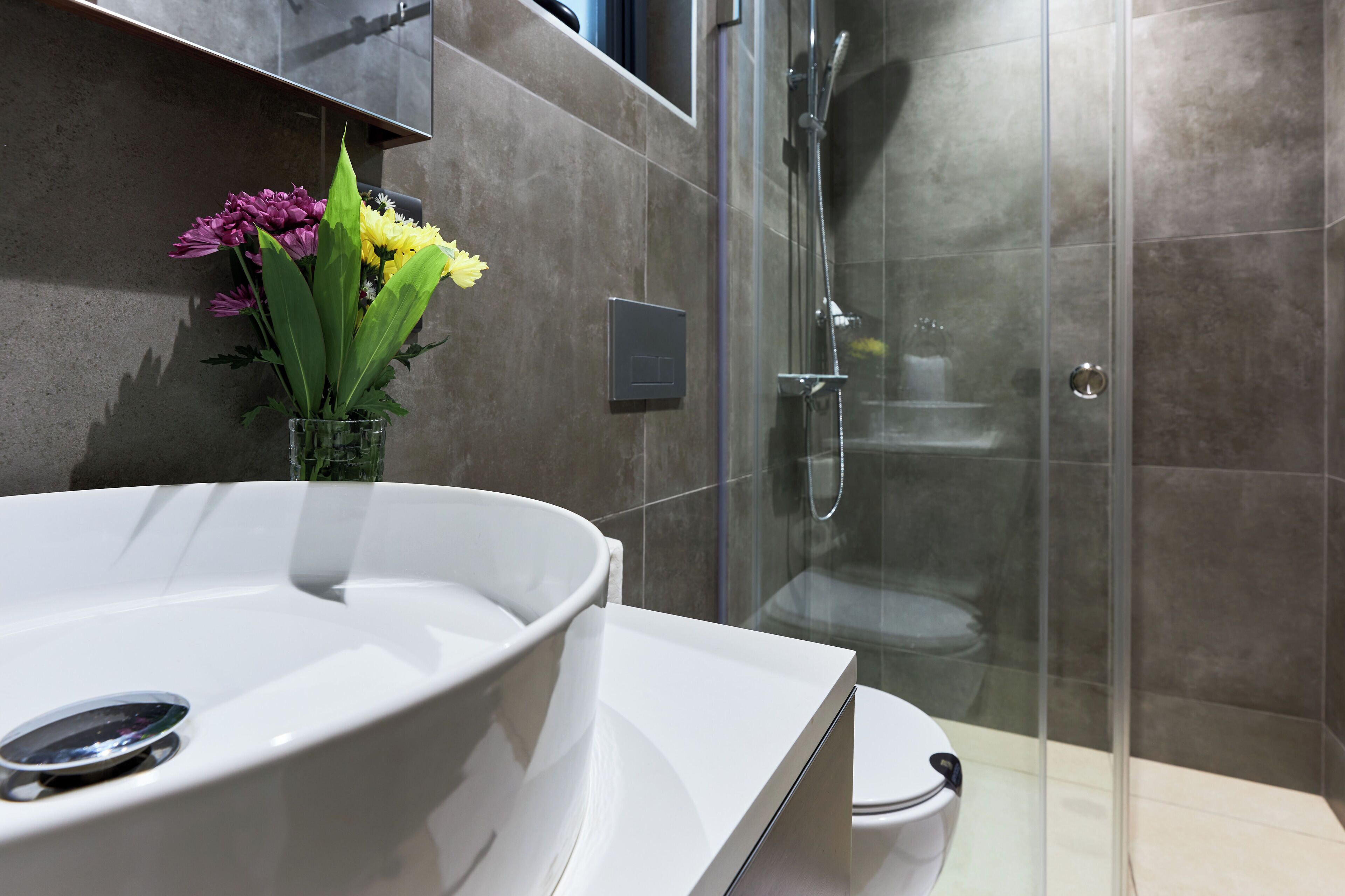 Un baño moderno con una bañera blanca grande, una cabina de ducha de vidrio y un inodoro.