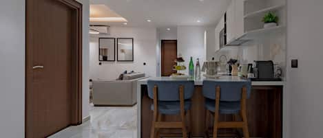 A modern kitchen with a central island, wooden chairs, and a dining table.