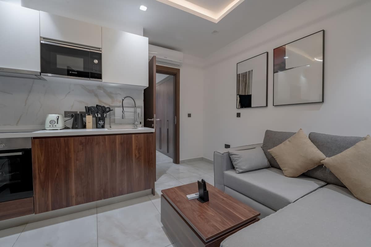 A modern kitchen with a built-in microwave, wooden cabinets, and a coffee table.
