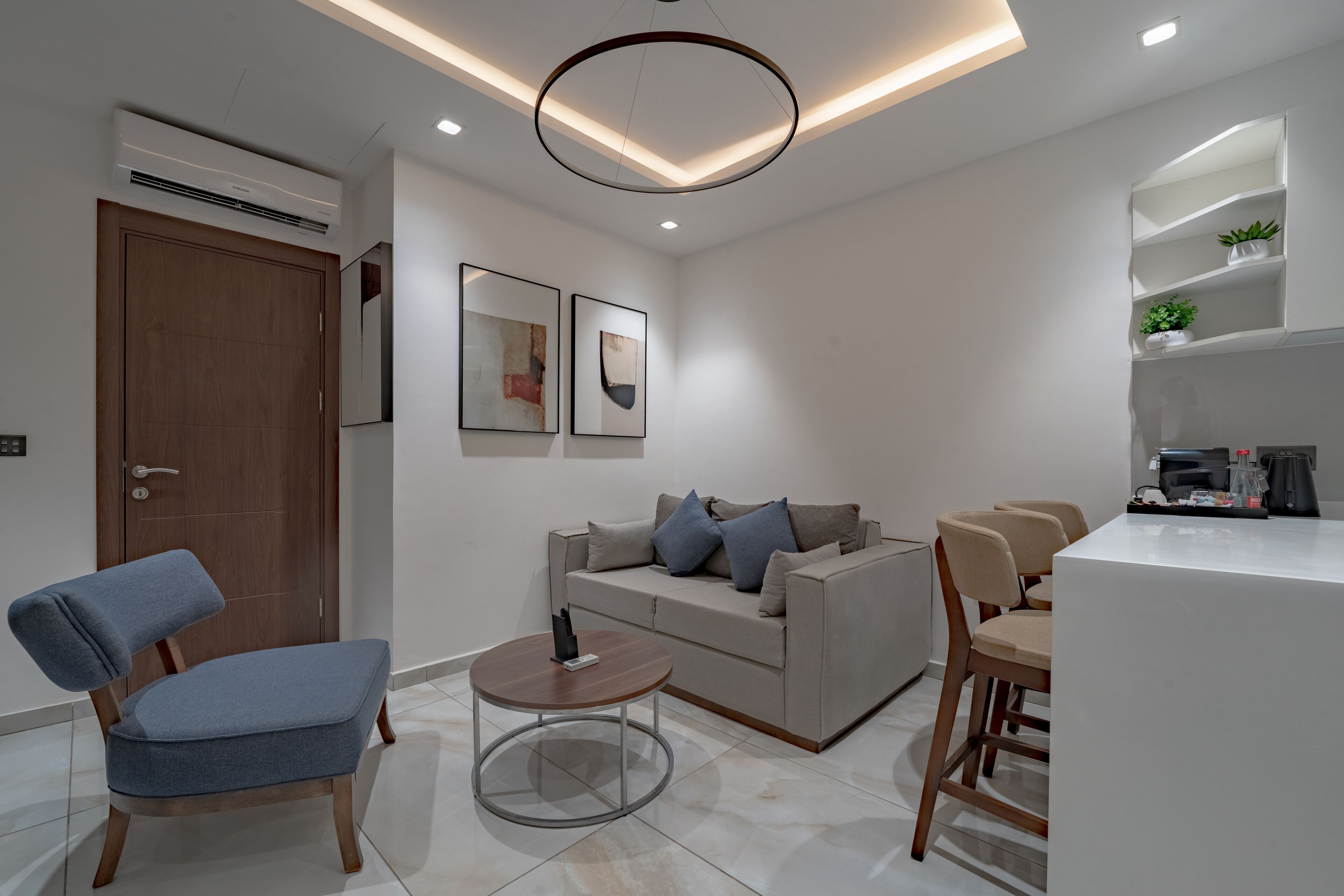 Uma sala de estar moderna com um sofá, uma mesa de centro e um espaço de jantar com cadeiras.