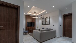Una sala moderna con un sofá, un televisor y un armario de madera.