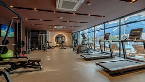 Un gimnasio moderno con cintas de correr, máquinas de pesas y pelotas de ejercicio.