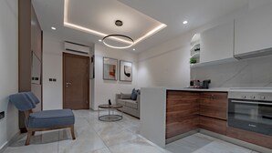 Una cocina moderna con horno Bosch, armarios de madera y piso de mármol.