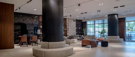 A spacious lobby with a central seating area, large windows, and a modern design.