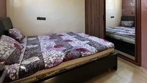 A bedroom with a bed, wooden wardrobe, and a ceiling light. - Cozy 2-bedroom apartment in enjoyable Agadir with WiFi (Agadir)
