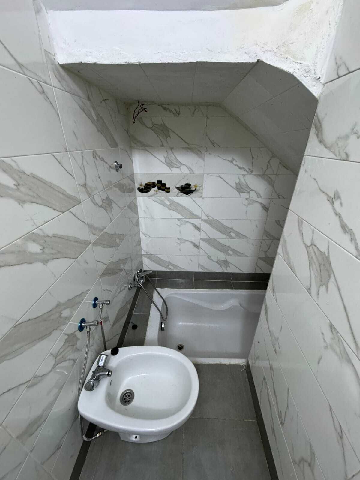 Une salle de bain équipée d’un bidet, d’une baignoire et de toilettes.