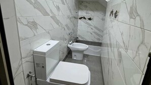 A small bathroom with a toilet, bidet, and a water heater. - Cozy 2-bedroom apartment in enjoyable Agadir with WiFi (Agadir)