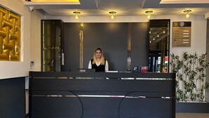 Ein Empfangsschalter mit modernem Design, einem digitalen Display und einer Schanze mit Zimmerpreisen.