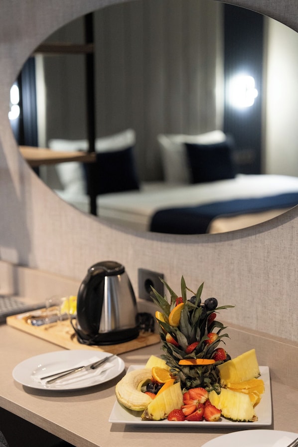 A hotel room with a breakfast tray on the table, a bed, and a mirror reflecting the room. - Lamore Otel (Ankara)