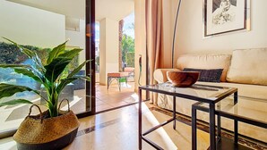 Ein modernes Wohnzimmer mit einer Couch, einem Couchtisch und einem großen Fenster.