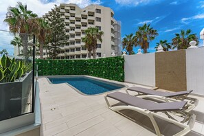 A rooftop pool area with lounge chairs and a view of a high-rise building. - Bal One bedroom apartment Adults Only (203) (Arona)