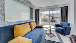 A modern living room with a blue sofa, a blue armchair, and a glass partition wall. - Bal One bedroom apartment Adults Only (204) (Arona)