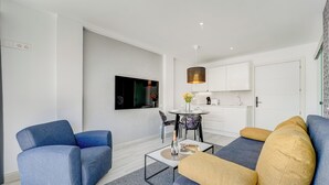 A modern living room with a sofa, a coffee table, and a dining area with chairs. - Bal One bedroom apartment Adults Only (204) (Arona)