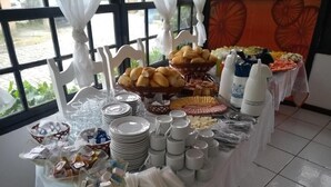 Een buffet met diverse gerechten, borden en bekers.