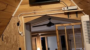 A wooden cabin with a TV mounted on the ceiling, a power strip, and a ceiling fan. - Charming 2-bedroom cabin with bonus loft, pet-friendly in Seeley Lake (Seeley Lake)