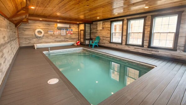 Swimmers can enjoy a refreshing dip in the rectangular pool surrounded by wooden flooring and natural light pouring in through the windows.