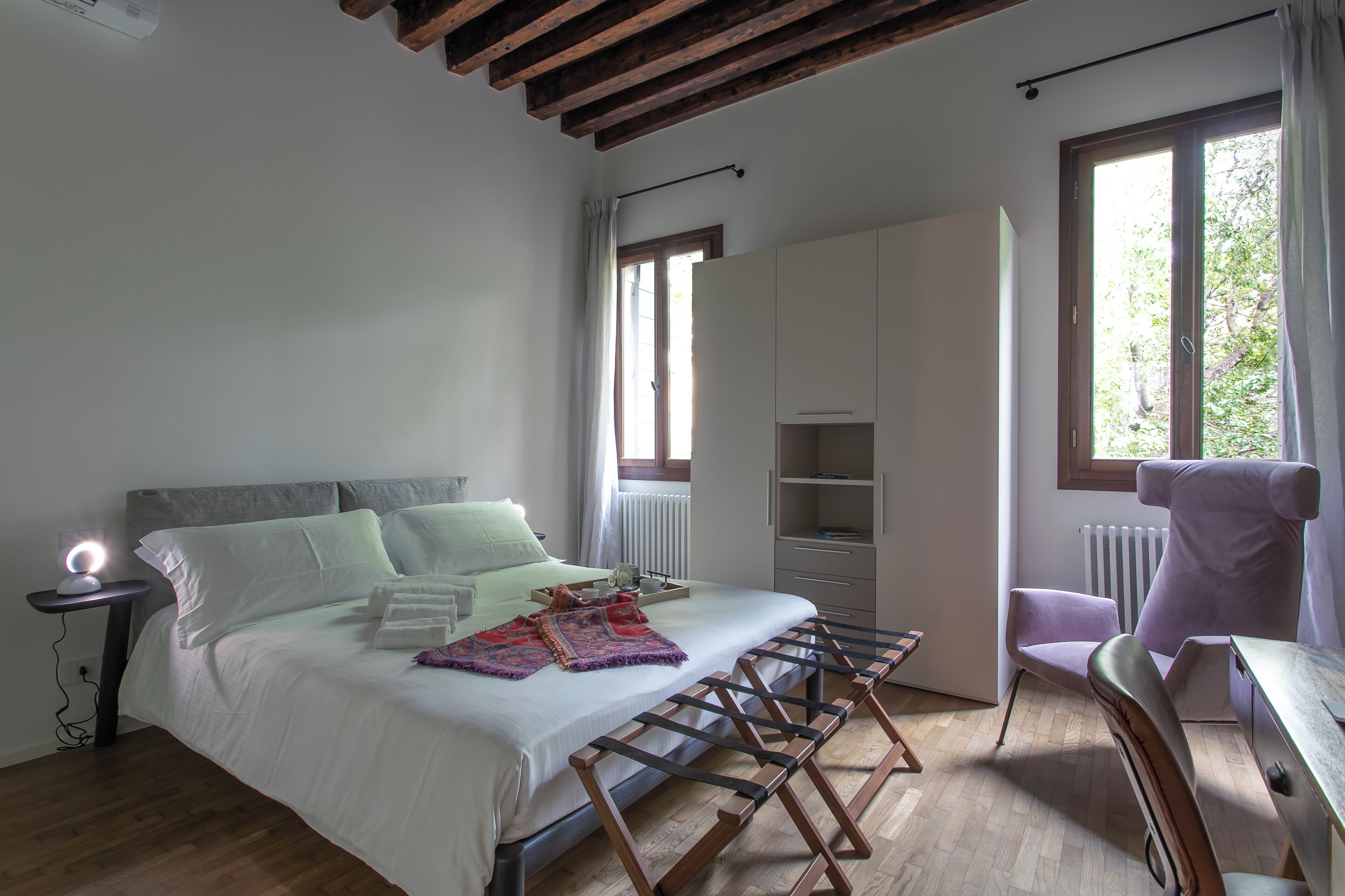 A bedroom with a bed, a desk, a chair, and a wardrobe.