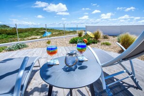 A deck with a table, two chairs, and two colorful drinks. - Villa Brisants - Oléron - Sea view & beach access (Saint-Pierre-d'Oléron)
