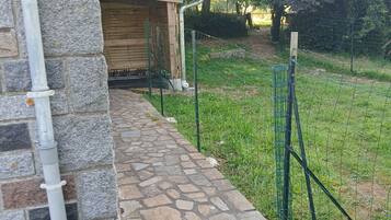 Un camino empedrado que conduce a una estructura de madera con una cerca metálica.