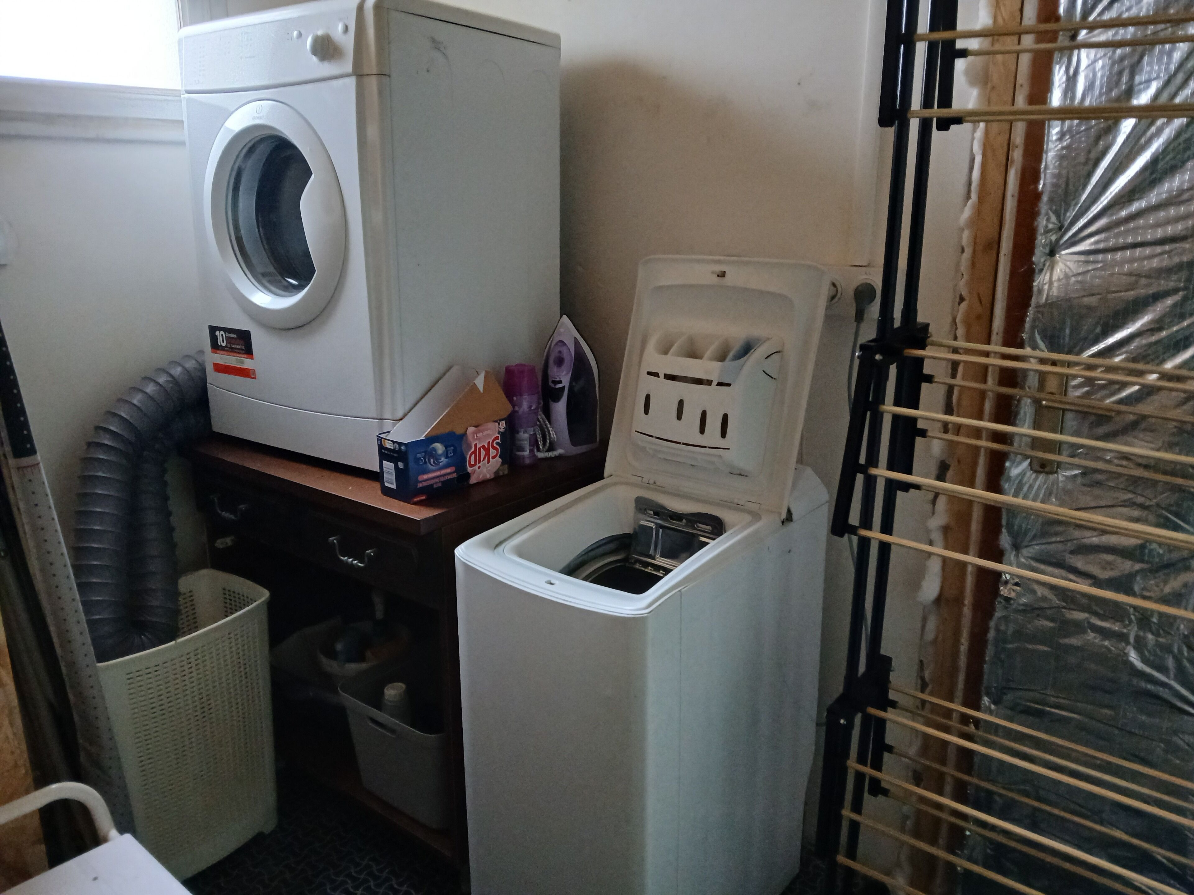 A laundry room with a front-loading washing machine, a dryer, and a utility sink.