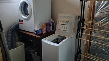 A laundry room with a front-loading washing machine, a dryer, and a utility sink.