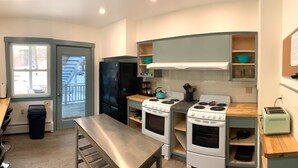 A compact kitchen with two stoves, a refrigerator, and a toaster. - The Northport Inn & Lodge (Belfast)